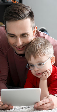 Father and son enjoying Broadband Internet on their tablet