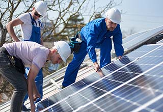 Three men installing solar panels