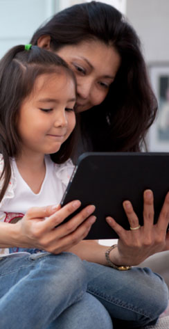 Woman and daughter looking at tablet device together
