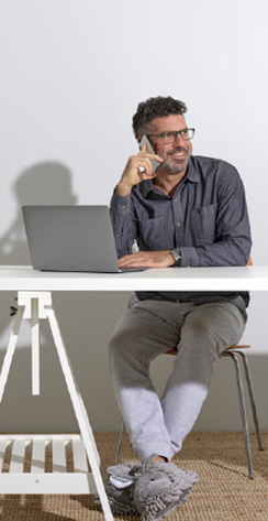 Man sitting outside at desk talking on mobile phone